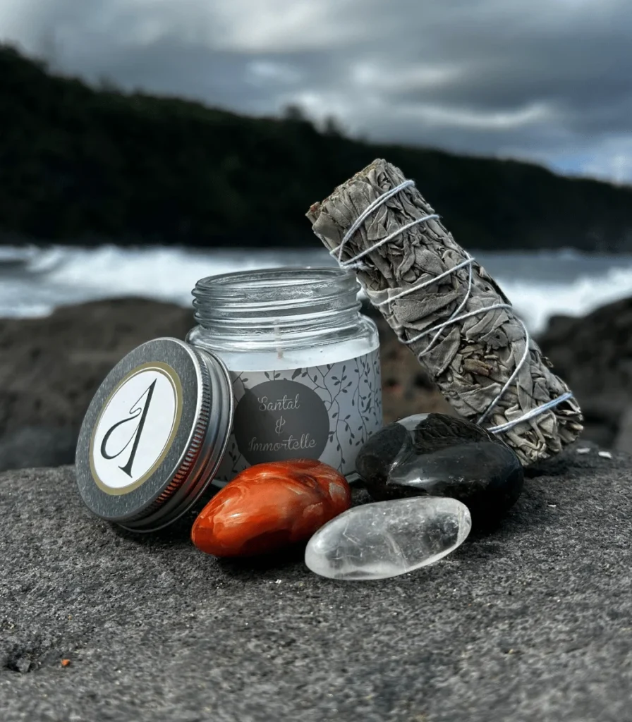 Bougie CESAME, sauge blanche et pierres posées sur la roche noire du littoral de La Réunion